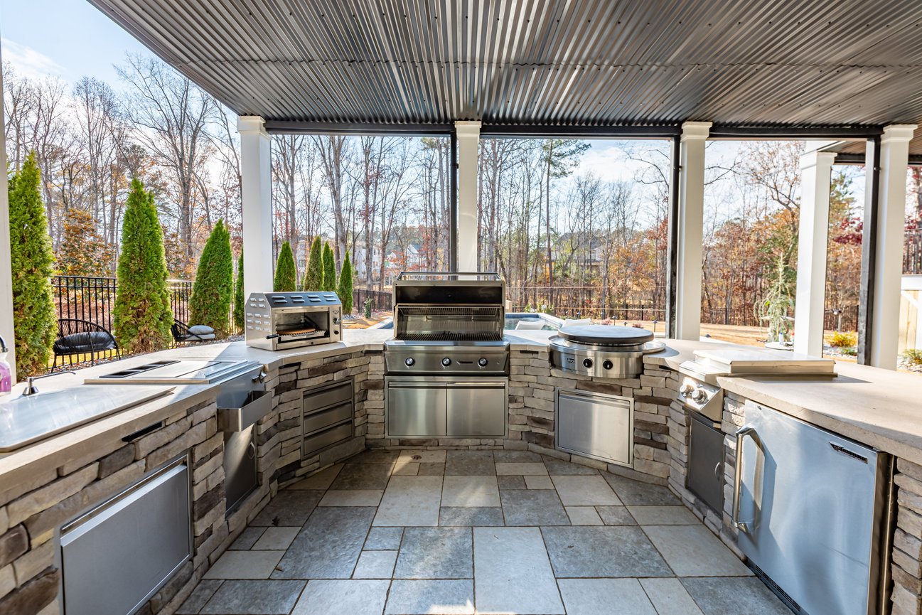 Luxurious Outdoor Kitchens in Monument featuring granite countertops and bar seating